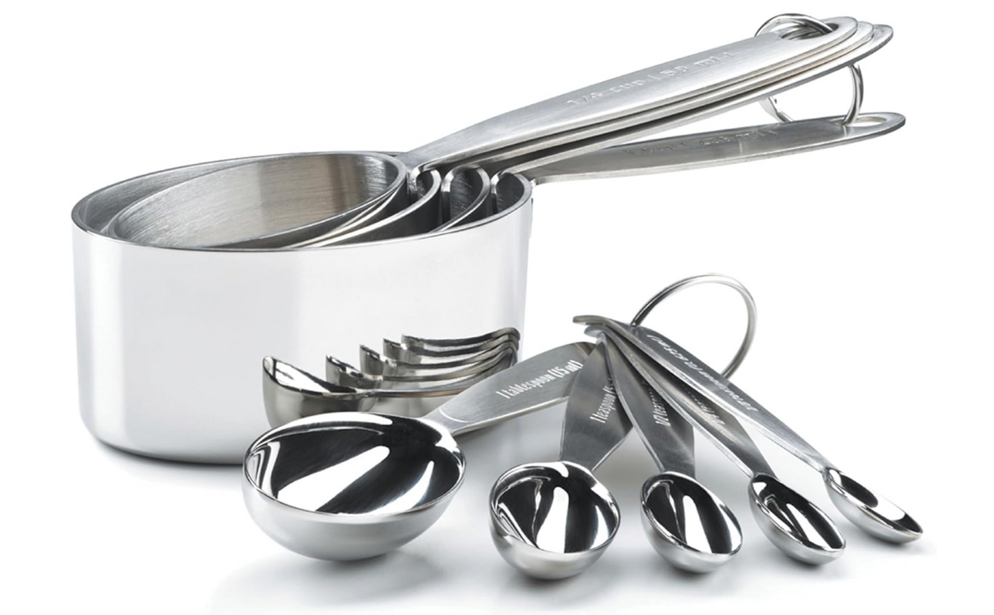 Set of stainless steel measuring cups and spoons on a white background